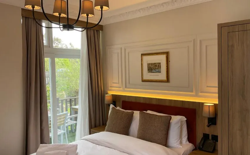 Superior Double with panelled walls and tall windows onto the river